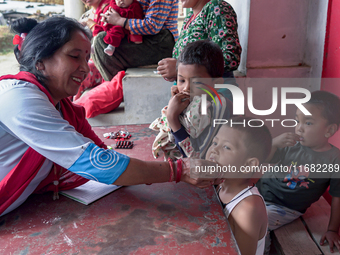 A health worker gives a Vitamin A capsule to a child in Dhading, Nepal, on October 19, 2024. (