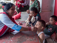 A health worker gives a Vitamin A capsule to a child in Dhading, Nepal, on October 19, 2024. (