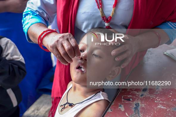 A health worker gives a Vitamin A capsule to a child in Dhading, Nepal, on October 19, 2024. 