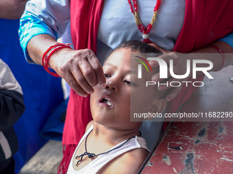 A health worker gives a Vitamin A capsule to a child in Dhading, Nepal, on October 19, 2024. (