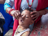 A health worker gives a Vitamin A capsule to a child in Dhading, Nepal, on October 19, 2024. (