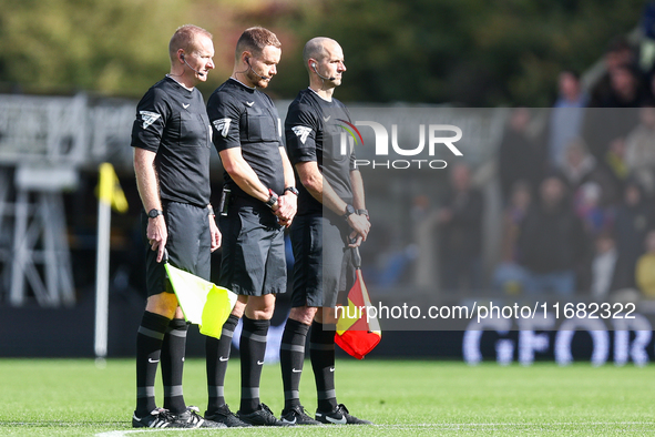 Assistant referee Matthew McGrath, referee Leigh Doughty, and assistant referee Nigel Lugg observe a minute's silence as they pay their resp...