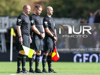 Assistant referee Matthew McGrath, referee Leigh Doughty, and assistant referee Nigel Lugg observe a minute's silence as they pay their resp...