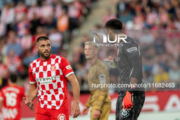 In Girona, Spain, on October 19, 2024, Paulo Gazzaniga of Girona FC and David Lopez of Girona FC are in action during the LaLiga EA Sports 2...