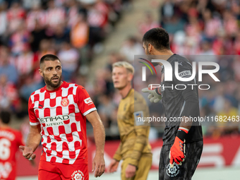 In Girona, Spain, on October 19, 2024, Paulo Gazzaniga of Girona FC and David Lopez of Girona FC are in action during the LaLiga EA Sports 2...