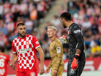 In Girona, Spain, on October 19, 2024, Paulo Gazzaniga of Girona FC and David Lopez of Girona FC are in action during the LaLiga EA Sports 2...