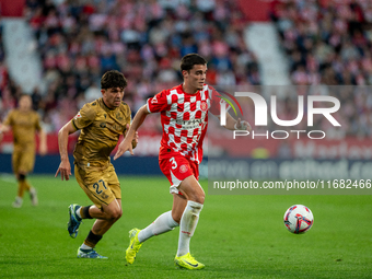 In Girona, Spain, on October 19, 2024, Jon Mikel Aramburu of Real Sociedad and Miguel Gutierrez of Girona FC compete for the ball during the...