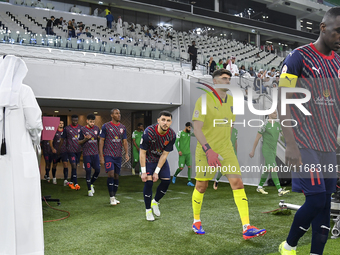 Al Duhail SC and Al Ahli SC players walk onto the pitch before the Ooredoo Qatar Stars League 24/25 match at Al Thumama Stadium in Doha, Qat...