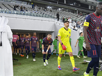 Al Duhail SC and Al Ahli SC players walk onto the pitch before the Ooredoo Qatar Stars League 24/25 match at Al Thumama Stadium in Doha, Qat...