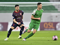 Bassam Hisham of Al Duhail FC battles for the ball with Julian Draxler of Al Ahli SC during the Ooredoo Qatar Stars League 24/25 match betwe...