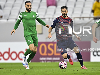 Luis Alberto (R) of Al Duhail FC battles for the ball with Driss Fettouhi of Al Ahli SC during the Ooredoo Qatar Stars League 24/25 match be...