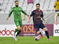 Luis Alberto (R) of Al Duhail FC battles for the ball with Driss Fettouhi of Al Ahli SC during the Ooredoo Qatar Stars League 24/25 match be...