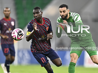 Almoez Abdulla (L) of Al Duhail FC battles for the ball with Driss Fettouhi of Al Ahli SC during the Ooredoo Qatar Stars League 24/25 match...