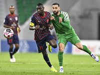 Almoez Abdulla (L) of Al Duhail FC battles for the ball with Driss Fettouhi of Al Ahli SC during the Ooredoo Qatar Stars League 24/25 match...