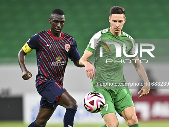 Almoez Abdulla of Al Duhail FC battles for the ball with Julian Draxler of Al Ahli SC during the Ooredoo Qatar Stars League 24/25 match betw...