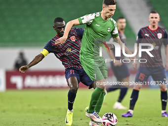 Almoez Abdulla of Al Duhail FC battles for the ball with Julian Draxler of Al Ahli SC during the Ooredoo Qatar Stars League 24/25 match betw...