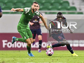 Almoez Abdulla (R) of Al Duhail FC battles for the ball with Bahaa Mamdouh Ellethy of Al Ahli SC during the Ooredoo Qatar Stars League 24/25...