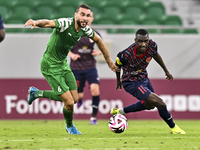 Almoez Abdulla (R) of Al Duhail FC battles for the ball with Bahaa Mamdouh Ellethy of Al Ahli SC during the Ooredoo Qatar Stars League 24/25...