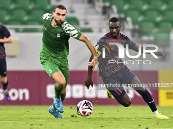 Almoez Abdulla (R) of Al Duhail FC battles for the ball with Bahaa Mamdouh Ellethy of Al Ahli SC during the Ooredoo Qatar Stars League 24/25...