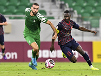 Almoez Abdulla (R) of Al Duhail FC battles for the ball with Bahaa Mamdouh Ellethy of Al Ahli SC during the Ooredoo Qatar Stars League 24/25...