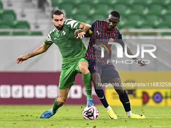 Almoez Abdulla (R) of Al Duhail FC battles for the ball with Bahaa Mamdouh Ellethy of Al Ahli SC during the Ooredoo Qatar Stars League 24/25...