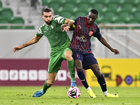 Almoez Abdulla (R) of Al Duhail FC battles for the ball with Bahaa Mamdouh Ellethy of Al Ahli SC during the Ooredoo Qatar Stars League 24/25...