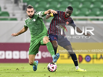 Almoez Abdulla (R) of Al Duhail FC battles for the ball with Bahaa Mamdouh Ellethy of Al Ahli SC during the Ooredoo Qatar Stars League 24/25...