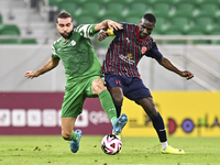 Almoez Abdulla (R) of Al Duhail FC battles for the ball with Bahaa Mamdouh Ellethy of Al Ahli SC during the Ooredoo Qatar Stars League 24/25...