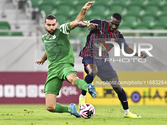 Almoez Abdulla (R) of Al Duhail FC battles for the ball with Bahaa Mamdouh Ellethy of Al Ahli SC during the Ooredoo Qatar Stars League 24/25...