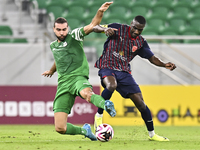 Almoez Abdulla (R) of Al Duhail FC battles for the ball with Bahaa Mamdouh Ellethy of Al Ahli SC during the Ooredoo Qatar Stars League 24/25...