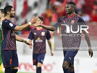 Michael Olunga (R) of Al Duhail FC celebrates with his teammate after scoring a goal during the Ooredoo Qatar Stars League 24/25 match betwe...