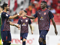 Michael Olunga (R) of Al Duhail FC celebrates with his teammate after scoring a goal during the Ooredoo Qatar Stars League 24/25 match betwe...