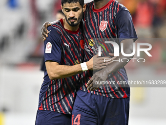 Michael Olunga (R) of Al Duhail FC celebrates with his teammate after scoring a goal during the Ooredoo Qatar Stars League 24/25 match betwe...