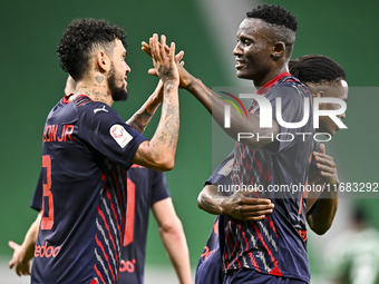 Michael Olunga (R) of Al Duhail FC celebrates with his teammate after scoring a goal during the Ooredoo Qatar Stars League 24/25 match betwe...