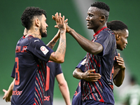 Michael Olunga (R) of Al Duhail FC celebrates with his teammate after scoring a goal during the Ooredoo Qatar Stars League 24/25 match betwe...