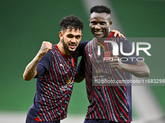 Michael Olunga (R) of Al Duhail FC celebrates with his teammate after scoring a goal during the Ooredoo Qatar Stars League 24/25 match betwe...