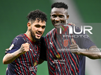 Michael Olunga (R) of Al Duhail FC celebrates with his teammate after scoring a goal during the Ooredoo Qatar Stars League 24/25 match betwe...