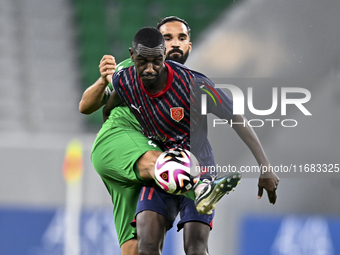 Almoez Abdulla (R) of Al Duhail FC battles for the ball with Talal Abdulla Bahzad of Al Ahli SC during the Ooredoo Qatar Stars League 24/25...