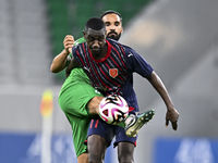 Almoez Abdulla (R) of Al Duhail FC battles for the ball with Talal Abdulla Bahzad of Al Ahli SC during the Ooredoo Qatar Stars League 24/25...