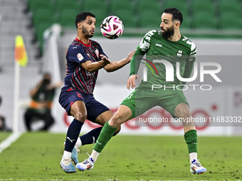 Abdullah Al Ahrak (L) of Al Duhail FC battles for the ball with Driss Fettouhi of Al Ahli SC during the Ooredoo Qatar Stars League 24/25 mat...