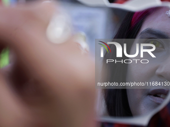 A woman applies makeup during the Zombie March in Mexico City, Mexico, on October 19, 2024, which starts from the Monument to the Revolution...