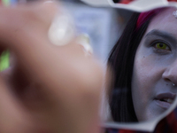 A woman applies makeup during the Zombie March in Mexico City, Mexico, on October 19, 2024, which starts from the Monument to the Revolution...