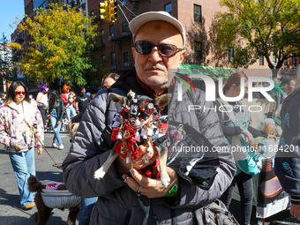 A man carries his dog as he marches in the 34th Annual Tompkins Square Halloween Dog Parade in Tompkins Square Park in New York City, USA, o...