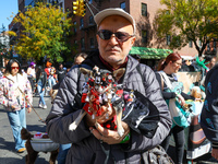 A man carries his dog as he marches in the 34th Annual Tompkins Square Halloween Dog Parade in Tompkins Square Park in New York City, USA, o...