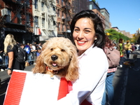 An owner carries her dog as they walk during the 34th Annual Tompkins Square Halloween Dog Parade in Tompkins Square Park in New York City,...