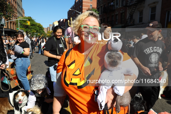 A dog dressed as Snoopy is carried by its owner during the 34th Annual Tompkins Square Halloween Dog Parade in Tompkins Square Park in New Y...