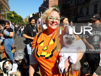 A dog dressed as Snoopy is carried by its owner during the 34th Annual Tompkins Square Halloween Dog Parade in Tompkins Square Park in New Y...