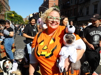 A dog dressed as Snoopy is carried by its owner during the 34th Annual Tompkins Square Halloween Dog Parade in Tompkins Square Park in New Y...