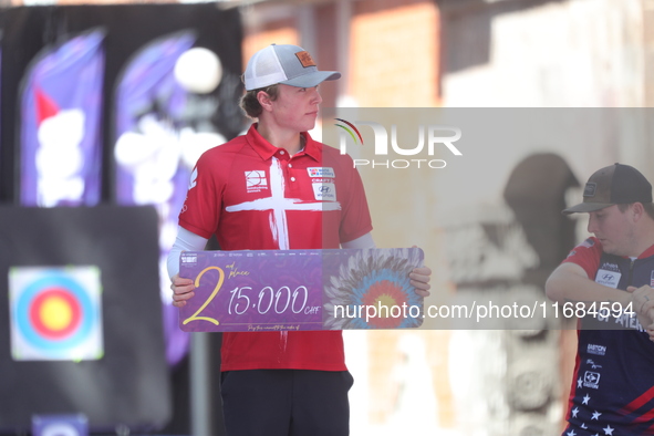 Silver medalist Mathias Fullerton of Denmark participates in the medal ceremony after the men's compound final match on the second day of th...