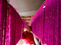 A Nepali florist arranges woven Gomphrena Globosa, commonly known as Makhmali garlands, at her house as she prepares for the festival of Tih...